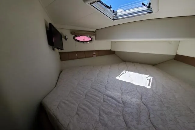 Basic Instinct Yacht Photos Pics 1995 Sea Ray 440 Express Bridge cabin with bed, skylight, and TV.