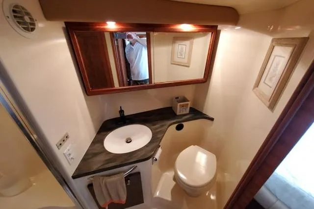 Basic Instinct Yacht Photos Pics Bathroom interior of 1995 Sea Ray 440 Express Bridge yacht, featuring sink and toilet.