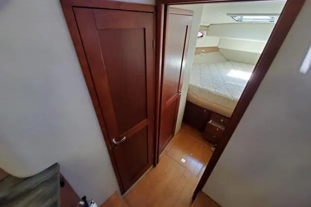 Basic Instinct Yacht Photos Pics Interior of 1995 Sea Ray 440 Express Bridge, featuring wood doors and cozy bedroom.