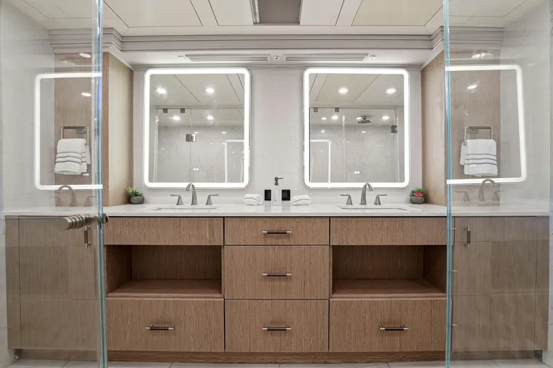 Panacea Yacht Photos Pics Luxurious yacht bathroom with dual sinks, illuminated mirrors, and modern wood cabinetry on Mengi Yay 115 MY.