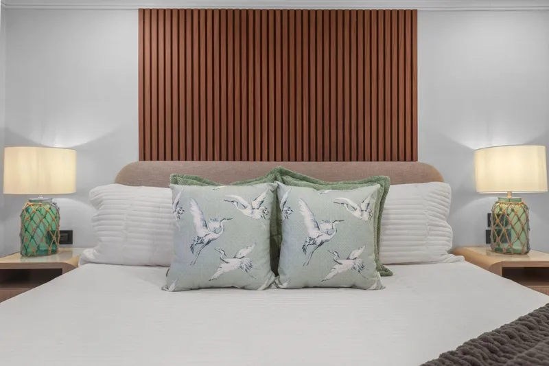 Panacea Yacht Photos Pics Luxurious bedroom on Mengi Yay 115 MY yacht, featuring elegant decor and bird-themed cushions.