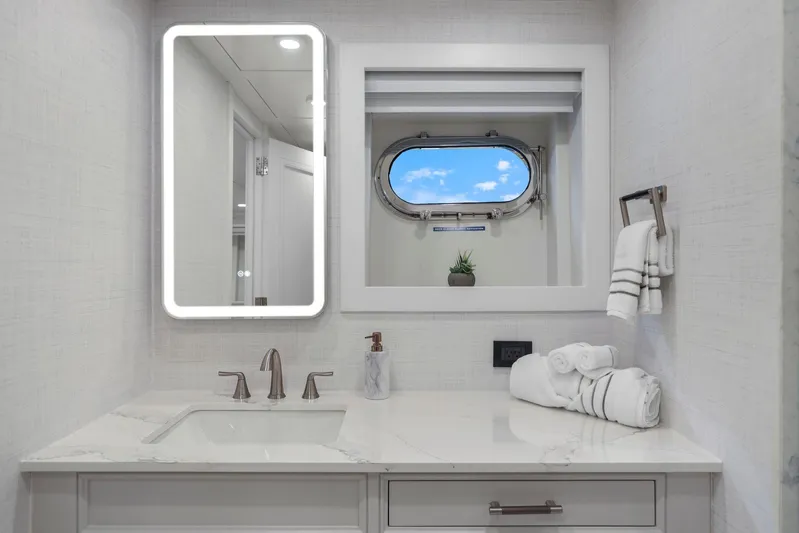 Panacea Yacht Photos Pics Luxurious yacht bathroom with modern fixtures, illuminated mirror, and ocean-view porthole. Mengi Yay 115 MY, 2011.