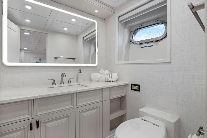 Panacea Yacht Photos Pics Luxurious yacht bathroom with modern fixtures, illuminated mirror, and porthole window on Mengi Yay 115 MY.
