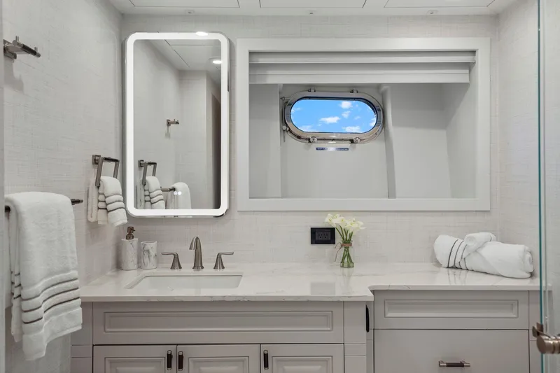 Panacea Yacht Photos Pics Luxurious yacht bathroom with modern fixtures, illuminated mirror, and ocean-view porthole. Mengi Yay 115 MY 2011.