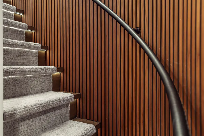 Panacea Yacht Photos Pics Carpeted stairs with wooden paneling and sleek black handrail on Mengi Yay 115 MY yacht.