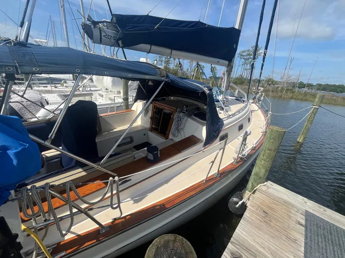  Yacht Photos Pics 1997 Island Packet 350 sailboat docked, featuring blue canvas covers and wooden deck accents.