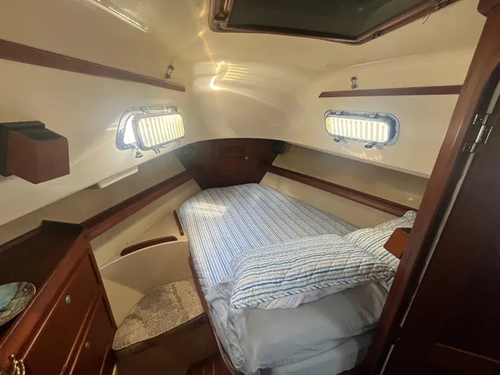  Yacht Photos Pics Cozy cabin interior of a 1997 Island Packet 350 sailboat with a neatly made bed.