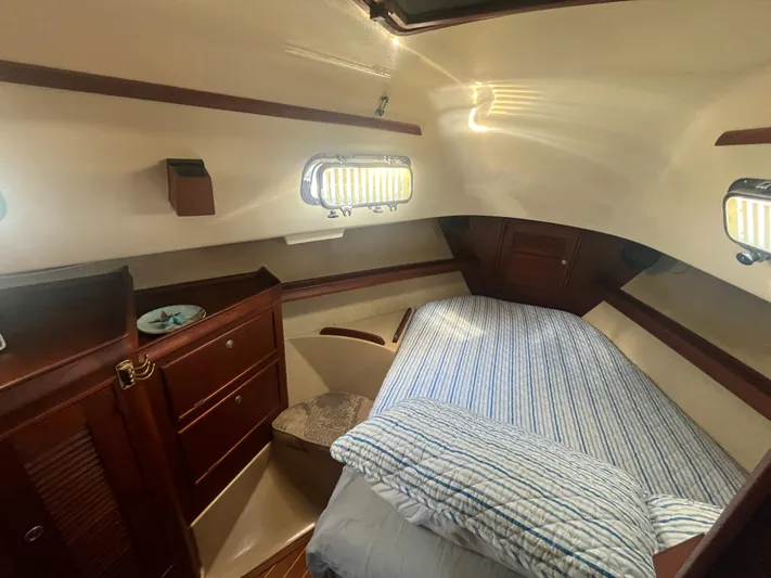  Yacht Photos Pics Cozy cabin interior of 1997 Island Packet 350 sailboat with striped bedding and wooden accents.