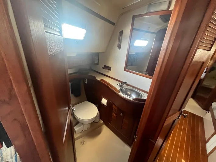  Yacht Photos Pics Interior of 1997 Island Packet 350 sailboat bathroom with wooden cabinetry and compact design.
