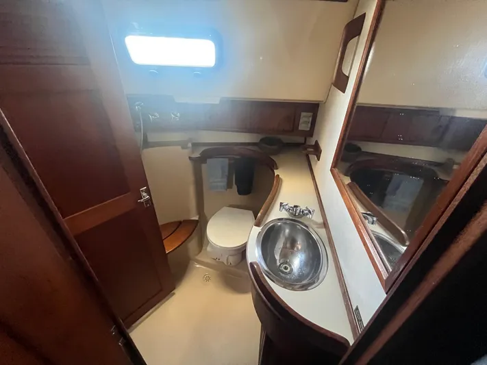  Yacht Photos Pics 1997 Island Packet 350 yacht bathroom with sink, toilet, and wooden accents.