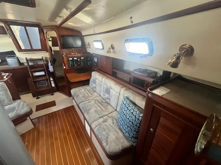  Yacht Photos Pics Interior of a 1997 Island Packet 350 sailboat with cozy seating and wooden accents.