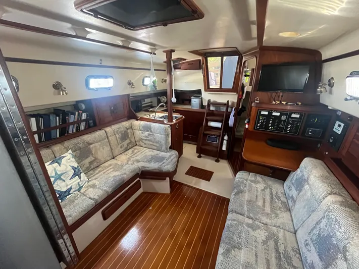  Yacht Photos Pics Interior of 1997 Island Packet 350 sailboat with cozy seating and wooden flooring.