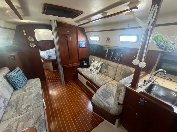 Yacht Photos Pics Interior of a 1997 Island Packet 350 sailboat with cozy seating and wooden flooring.