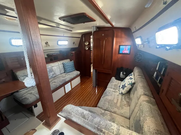  Yacht Photos Pics Interior of 1997 Island Packet 350 sailboat with cozy seating and wooden finishes.
