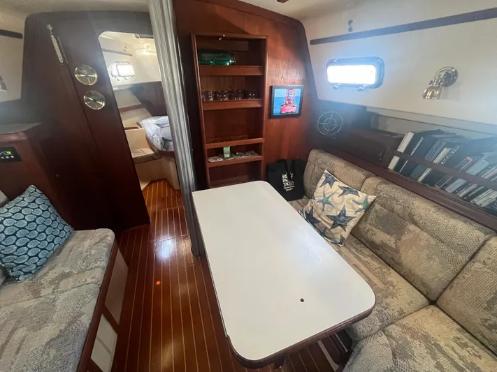  Yacht Photos Pics Interior of a 1997 Island Packet 350 sailboat with cozy seating and wooden accents.