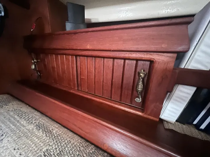  Yacht Photos Pics Wooden interior detail of a 1997 Island Packet 350 sailboat, featuring a cabinet with brass handles.