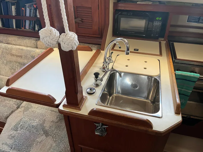  Yacht Photos Pics Interior of a 1997 Island Packet 350 sailboat kitchen with sink and microwave.