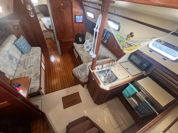  Yacht Photos Pics Interior of 1997 Island Packet 350 sailboat with cozy seating and kitchen area.