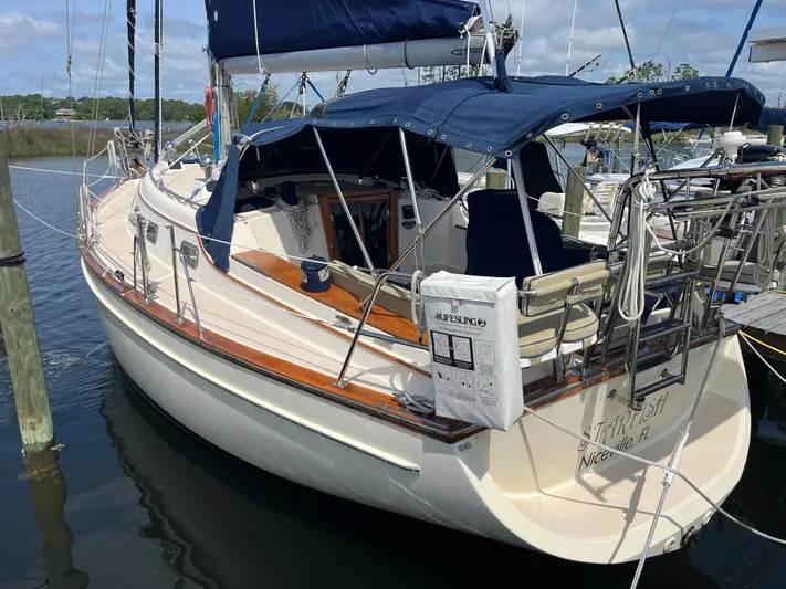  Yacht Photos Pics 1997 Island Packet 350 sailboat docked, featuring blue canvas covers and wooden accents.