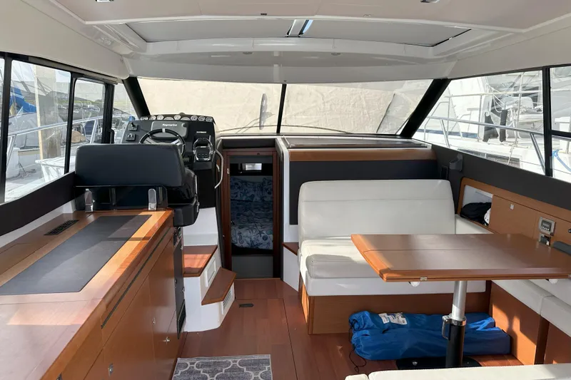 Tea Moana Yacht Photos Pics Interior of 2016 Jeanneau NC 11 boat with modern seating and helm.