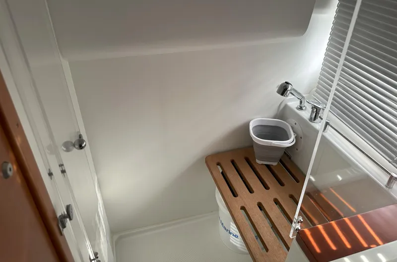 Tea Moana Yacht Photos Pics 2016 Jeanneau NC 11 bathroom with compact sink and wooden floor panel.