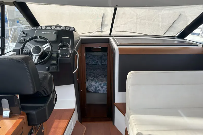 Tea Moana Yacht Photos Pics Interior of 2016 Jeanneau NC 11 boat, featuring helm, seating, and cabin entrance.