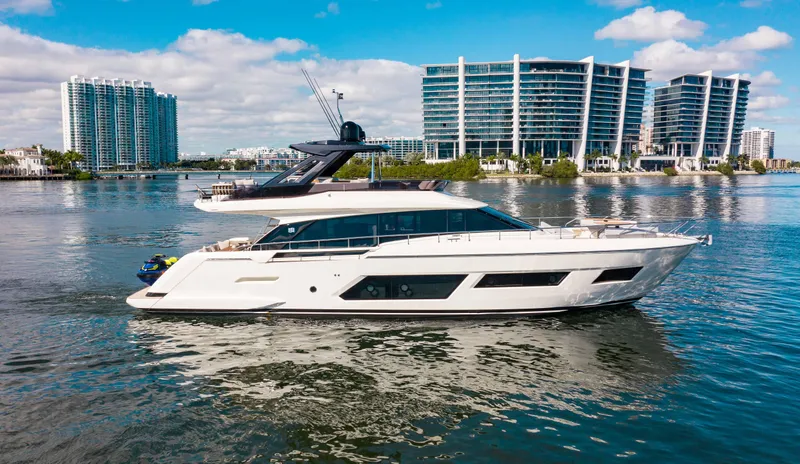 Our Trade Yacht Photos Pics 2022 Ferretti Yachts 670 cruising on water with modern buildings in the background.