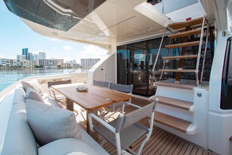 Our Trade Yacht Photos Pics Luxurious 2022 Ferretti Yachts 670 deck with dining area and city skyline view.