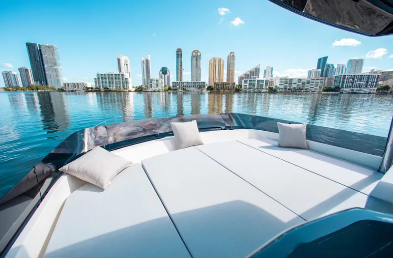 Our Trade Yacht Photos Pics Luxurious 2022 Ferretti Yachts 670 with city skyline view, featuring spacious sunbathing area.