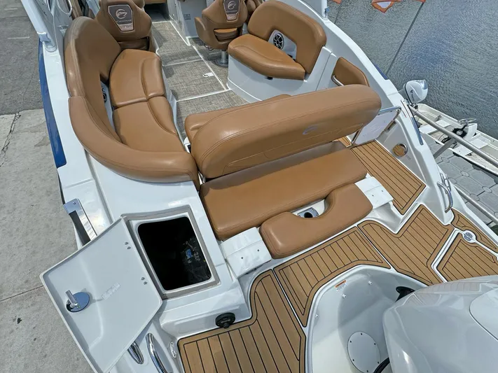  Yacht Photos Pics 2024 Crownline 290 XSS boat interior with tan leather seating and wood-style flooring.