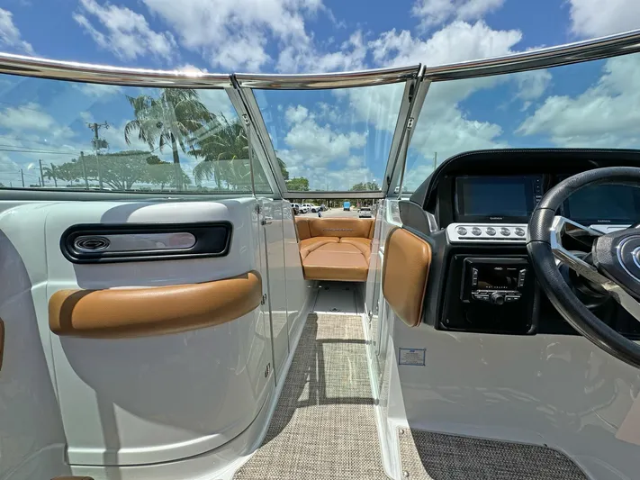  Yacht Photos Pics 2024 Crownline 290 XSS boat interior with steering wheel, seating, and clear skies.