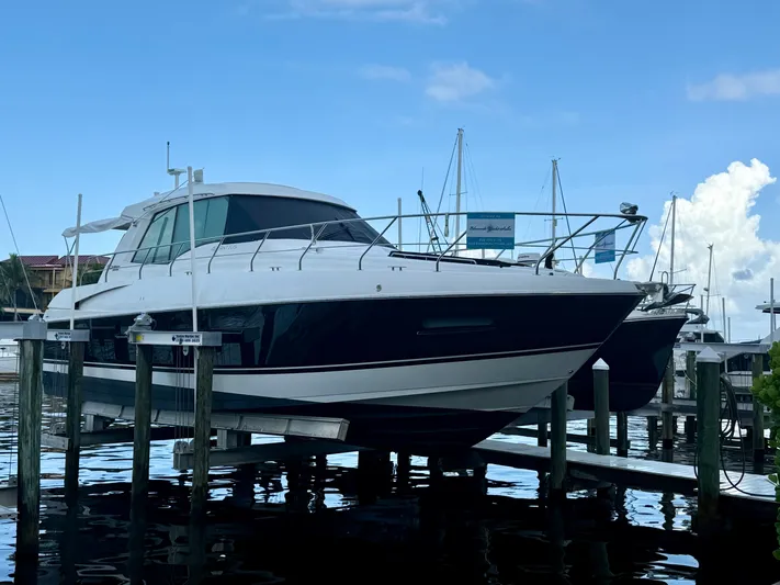 Bushels Of Fun VII Yacht Photos Pics 2012 Cruisers Yachts 48 Cantius docked at marina under clear blue sky.