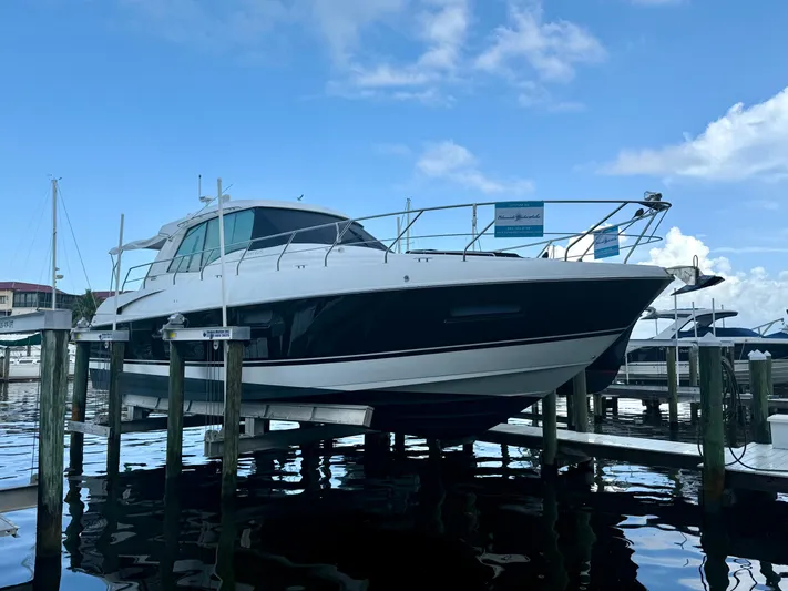 Bushels Of Fun VII Yacht Photos Pics 2012 Cruisers Yachts 48 Cantius docked at marina under blue sky.