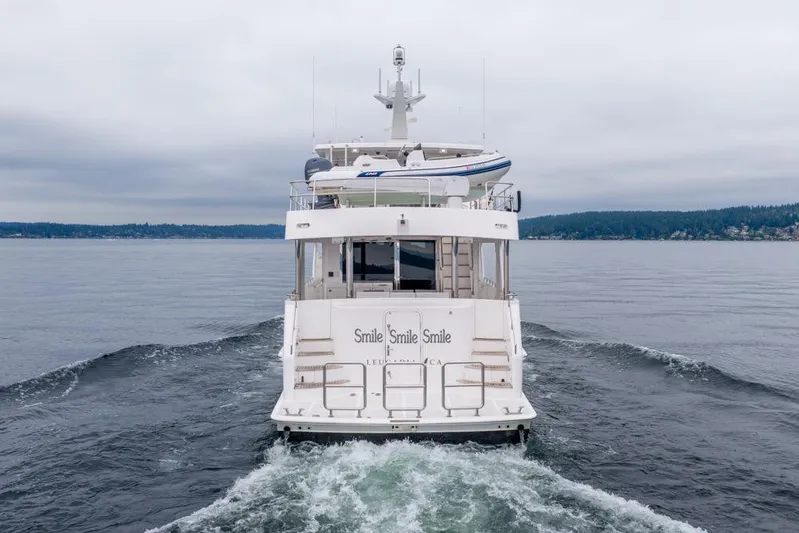 Smile Smile Smile Yacht Photos Pics 2022 Outer Reef 720 Motor Yacht cruising on calm waters, rear view.