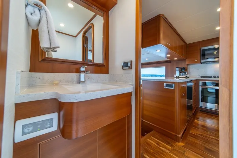 Smile Smile Smile Yacht Photos Pics Luxurious 2022 Outer Reef 720 Motor Yacht interior with modern kitchen and bathroom.