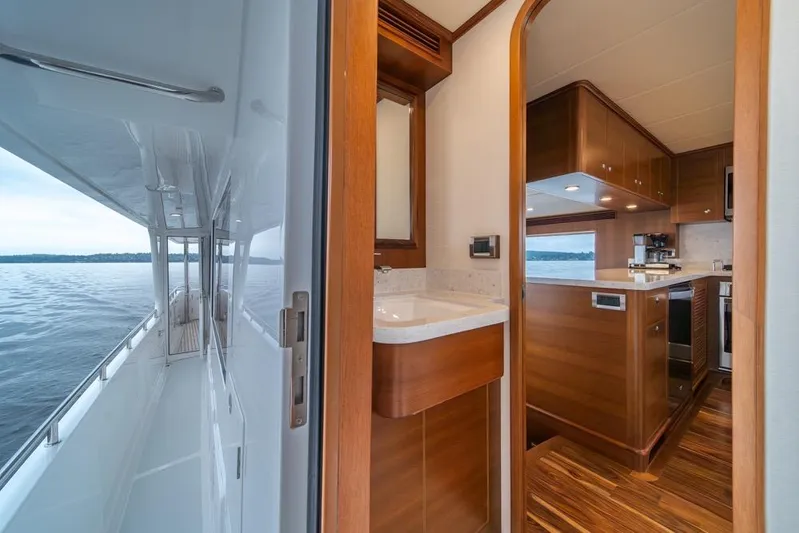 Smile Smile Smile Yacht Photos Pics Luxurious interior of 2022 Outer Reef 720 Motor Yacht with wooden finishes and ocean view.