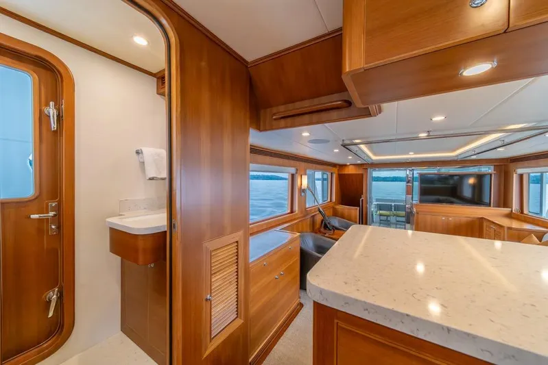 Smile Smile Smile Yacht Photos Pics Luxurious interior of 2022 Outer Reef 720 Motor Yacht with wood finishes and ocean view.