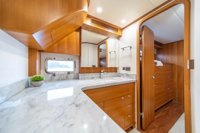 Smile Smile Smile Yacht Photos Pics Luxurious bathroom interior of 2022 Outer Reef 720 Motor Yacht with wooden cabinetry and marble countertop.