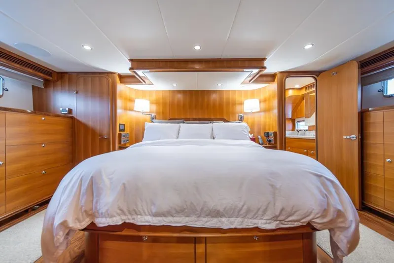 Smile Smile Smile Yacht Photos Pics Luxurious bedroom interior of 2022 Outer Reef 720 Motor Yacht with elegant wood finish.