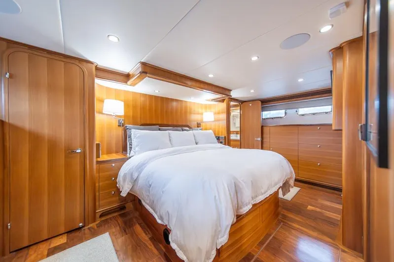 Smile Smile Smile Yacht Photos Pics Luxurious bedroom interior of 2022 Outer Reef 720 Motor Yacht with elegant wood finish.