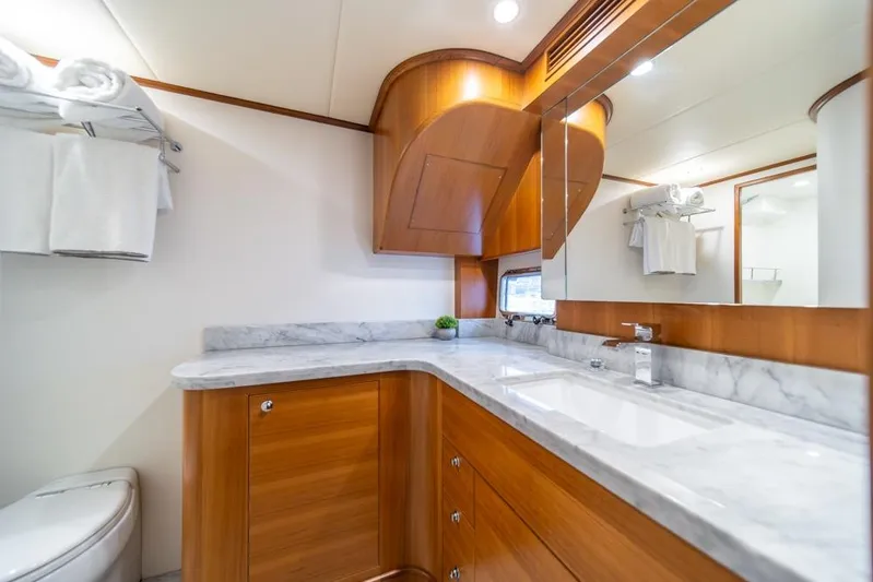 Smile Smile Smile Yacht Photos Pics Luxurious bathroom in 2022 Outer Reef 720 Motor Yacht with marble countertop and wooden cabinetry.