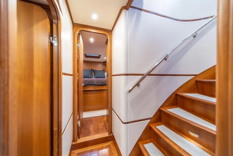 Smile Smile Smile Yacht Photos Pics Luxurious interior of 2022 Outer Reef 720 Motor Yacht with wooden finishes and staircase.