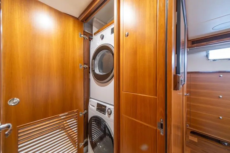 Smile Smile Smile Yacht Photos Pics Laundry area with stacked washer and dryer in 2022 Outer Reef 720 Motor Yacht.