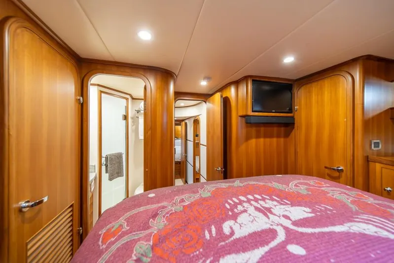 Smile Smile Smile Yacht Photos Pics Luxurious cabin interior of 2022 Outer Reef 720 Motor Yacht with wood paneling and TV.