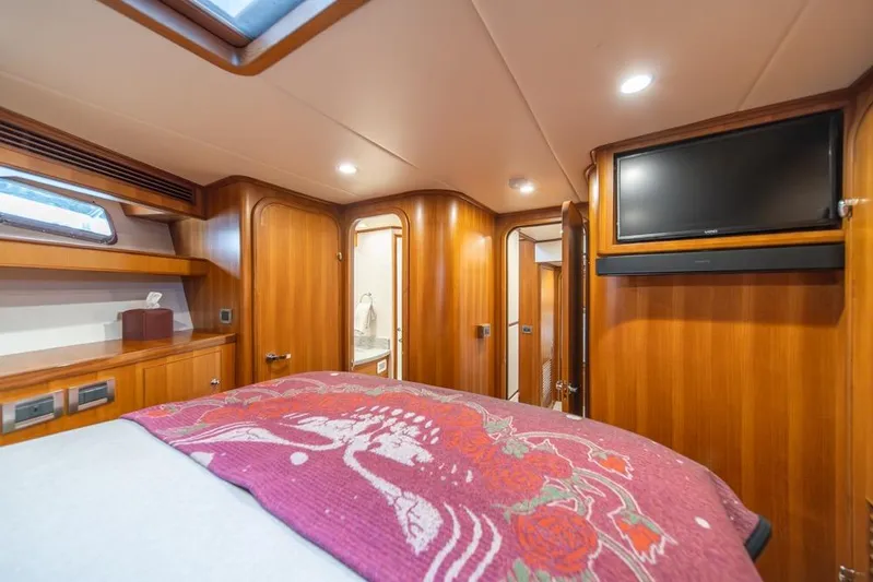 Smile Smile Smile Yacht Photos Pics Luxurious 2022 Outer Reef 720 Motor Yacht bedroom with wood paneling and modern amenities.
