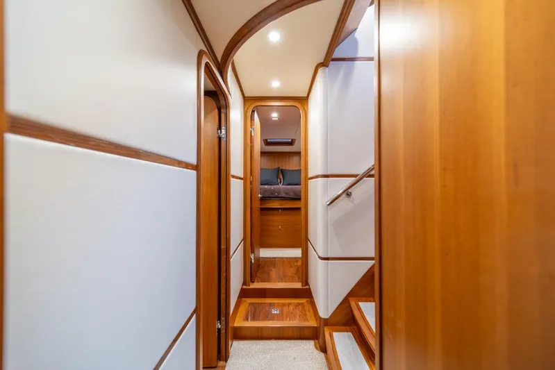 Smile Smile Smile Yacht Photos Pics Luxurious interior hallway of 2022 Outer Reef 720 Motor Yacht with wood accents.