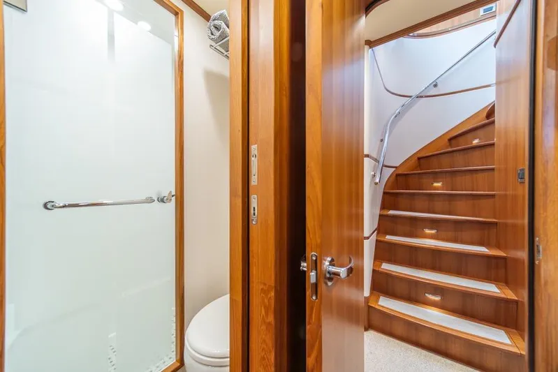 Smile Smile Smile Yacht Photos Pics Luxurious 2022 Outer Reef 720 Motor Yacht interior with wooden staircase and bathroom.