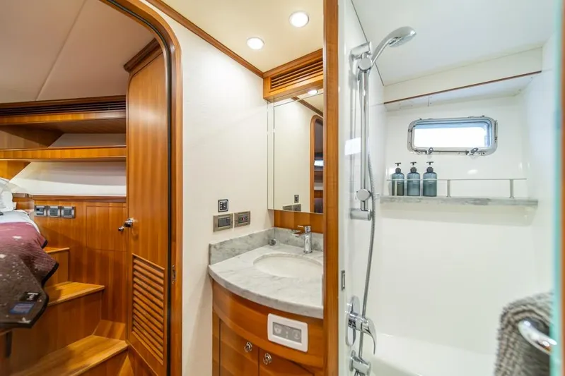 Smile Smile Smile Yacht Photos Pics Luxurious bathroom interior of 2022 Outer Reef 720 Motor Yacht with wood accents and modern fixtures.