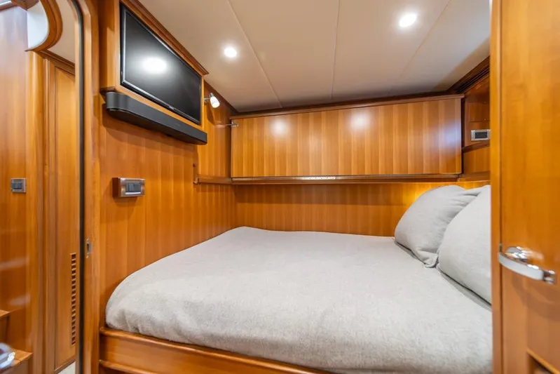 Smile Smile Smile Yacht Photos Pics Luxurious cabin interior of 2022 Outer Reef 720 Motor Yacht with wood paneling and TV.
