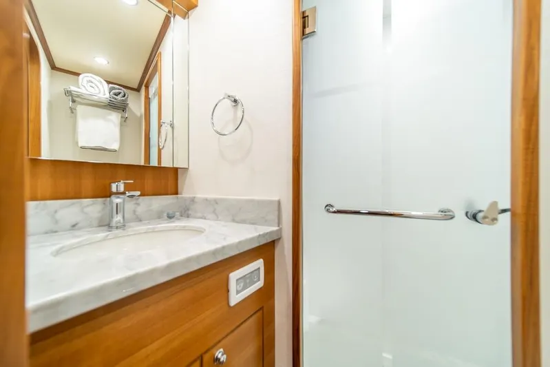 Smile Smile Smile Yacht Photos Pics Luxurious bathroom in 2022 Outer Reef 720 Motor Yacht with marble countertop and glass shower.